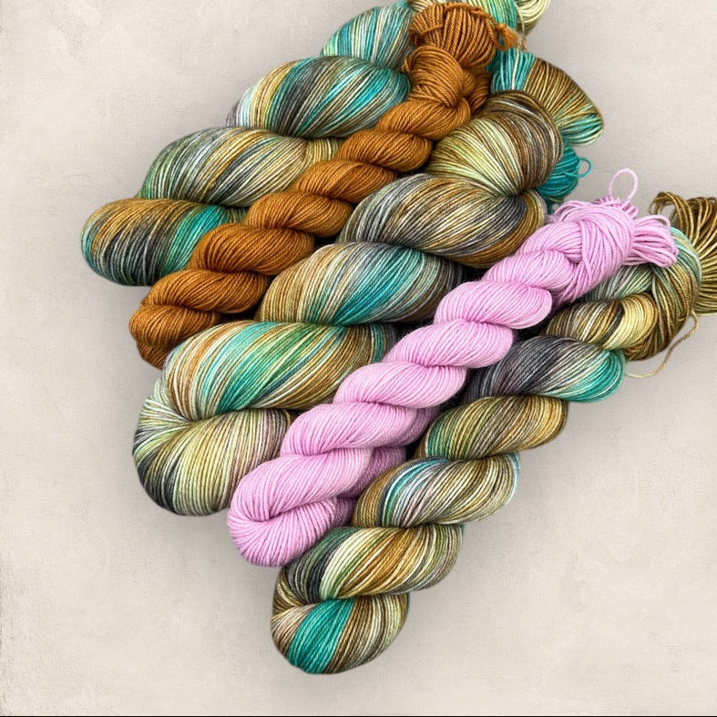 Colorful skeins of hand dyed yarn on a light background