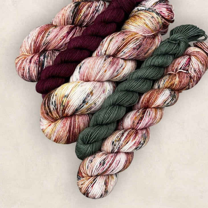 Multicolored skeins of yarn arranged in a decorative pattern on a light background